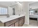 Double vanity bathroom with dark brown cabinets and a view into the bedroom at 9736 Black Willow Ln, Ladson, SC 29456