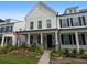 Two-story white farmhouse-style home with a front porch and landscaped yard at 1011 Swamp Harrier Ave, Ravenel, SC 29470