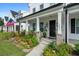 Charming front porch with brick columns, lanterns and lush landscaping at 1011 Swamp Harrier Ave, Ravenel, SC 29470