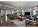 Spacious living room featuring hardwood floors, leather furniture, and a modern chandelier at 1011 Swamp Harrier Ave, Ravenel, SC 29470