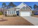 One-story home with stone accents and a two-car garage at 1040 Wading Point Blvd, Huger, SC 29450