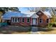 Brick home with metal roof, white door, and landscaped yard at 12240 Green Pond Hwy, Green Pond, SC 29446
