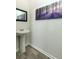 Small bathroom with pedestal sink, dark framed mirror, and wood-look flooring at 135 Sunray Ln, Summerville, SC 29486