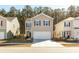 Two-story house with beige siding, white garage door, and landscaping at 135 Sunray Ln, Summerville, SC 29486