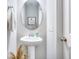 Small bathroom with pedestal sink and circular mirror at 240 Godwit Dr, Summerville, SC 29486