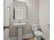 Modern powder room with a sleek pedestal sink, elongated toilet, and decorative mirror at 351 Wappoo Trace Ln, Summerville, SC 29486