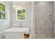 Bathroom featuring soaking tub with chrome fixtures and glass enclosed shower with marble tiles at 362 6Th Ave, Mount Pleasant, SC 29464