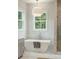 Bathroom featuring soaking tub, chrome fixtures, large window and glass enclosed shower at 362 6Th Ave, Mount Pleasant, SC 29464
