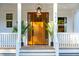 Wooden front door flanked by potted plants on a white porch at 362 6Th Ave, Mount Pleasant, SC 29464