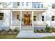 White porch with wooden door, railing, and potted plants at 362 6Th Ave, Mount Pleasant, SC 29464