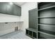 Laundry room with dark cabinets, geometric tile, and built-in shelving at 362 6Th Ave, Mount Pleasant, SC 29464
