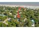 Aerial view of a house near the beach, with tennis courts and other homes visible at 420 E Erie Ave, Folly Beach, SC 29439