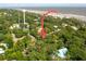 Aerial view of a beach house close to the ocean, surrounded by lush greenery at 420 E Erie Ave, Folly Beach, SC 29439