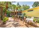 Outdoor patio, dining area, and tropical landscaping with palm trees at 420 E Erie Ave, Folly Beach, SC 29439