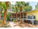 Home exterior with a deck, stairs, screened porch, and palm trees at 420 E Erie Ave, Folly Beach, SC 29439