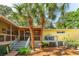Home exterior with a deck, stairs, screened porch, and palm trees at 420 E Erie Ave, Folly Beach, SC 29439