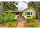 Yellow cottage with brick walkway, landscaping, and awning at 420 E Erie Ave, Folly Beach, SC 29439