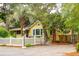 Yellow cottage with white picket fence, bicycle, and lush landscaping at 420 E Erie Ave, Folly Beach, SC 29439