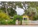 Yellow cottage with white picket fence and lush landscaping at 420 E Erie Ave, Folly Beach, SC 29439