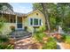 Yellow cottage with brick steps, landscaping, and awning at 420 E Erie Ave, Folly Beach, SC 29439