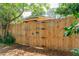 Wooden fence with artistic gate featuring whimsical designs at 420 E Erie Ave, Folly Beach, SC 29439