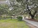 Mature oak trees and a well-manicured lawn enhance curb appeal at 488 Society Rd, McClellanville, SC 29458