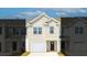 Two-story townhome with beige siding, white garage door, and dark-colored front door at 526 Golden Embers Way, Summerville, SC 29486