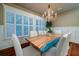 Elegant dining room with hardwood floors, large windows, and statement chandelier at 6124 Rudder Ln, Awendaw, SC 29429
