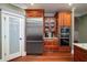 Modern kitchen with stainless steel refrigerator, custom cabinetry, and hardwood floors at 6124 Rudder Ln, Awendaw, SC 29429