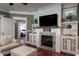Living room with fireplace, built-in shelving, and a view into a bedroom at 6124 Rudder Ln, Awendaw, SC 29429