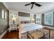 Bright main bedroom with hardwood floors, a large bed, and plantation shutters at 6124 Rudder Ln, Awendaw, SC 29429