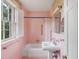 Pink bathroom with pedestal sink, shower, and vintage wallpaper at 14 Johnson Rd, Charleston, SC 29407