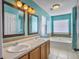 Bathroom with double sinks, a bathtub, and updated light fixtures at 173 Hainsworth Dr, North Charleston, SC 29418