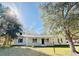 White house with a front porch, and large trees in the yard at 1966 Suzanne St, Johns Island, SC 29455