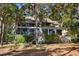Back of house with large windows and deck, surrounded by lush trees at 2942 Seabrook Island Rd, Seabrook Island, SC 29455