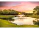 Serene community pond with fountain, lush greenery, and sunset reflection at 307 Pimpernel St, Summerville, SC 29483