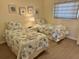 Bedroom with twin beds, nightstand, and coastal decor at 3701 Dock Site Rd # 205, Edisto Beach, SC 29438