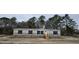 Beige manufactured home with black shutters and a wooden staircase at 126 Addison Rd, Harleyville, SC 29448