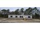 Beige manufactured home with black shutters and a wooden staircase at 126 Addison Rd, Harleyville, SC 29448