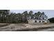 Beige manufactured home with black shutters and a wooden staircase at 126 Addison Rd, Harleyville, SC 29448