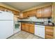 Kitchen with wood cabinets, white appliances, and tile flooring at 1836 Mepkin Rd # D5, Charleston, SC 29407