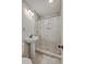 Bathroom with stylish vanity sink, tiled floors, and walk-in shower featuring elegant tiling and convenient recessed shelving at 2664 Hull St, North Charleston, SC 29405