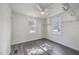 A bright bedroom with two windows, closet organizer, ceiling fan and grey hard surface floors at 2664 Hull St, North Charleston, SC 29405