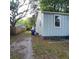 View of a home's exterior, showing light siding and a blue waste bin near a wooden fence at 2664 Hull St, North Charleston, SC 29405