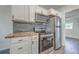 Updated kitchen features stainless steel appliances, wood countertop, modern backsplash, and white cabinets at 2664 Hull St, North Charleston, SC 29405