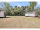 Large, open backyard features recently cut grass, landscaping, and access to the white house and accessory building at 3874 Srevir Rd, Johns Island, SC 29455