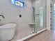 Luxurious bathroom with soaking tub, walk-in shower, and marble tile at 3874 Srevir Rd, Johns Island, SC 29455