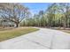 Long, paved driveway leading up to a two-story home with large, mature trees and landscaping along the side at 3874 Srevir Rd, Johns Island, SC 29455