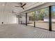 Spacious outdoor porch overlooking the backyard features ceiling fans, recessed lighting and a gray-stained deck at 3874 Srevir Rd, Johns Island, SC 29455