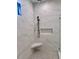 Walk-in shower with marble tile and built-in seat at 3874 Srevir Rd, Johns Island, SC 29455